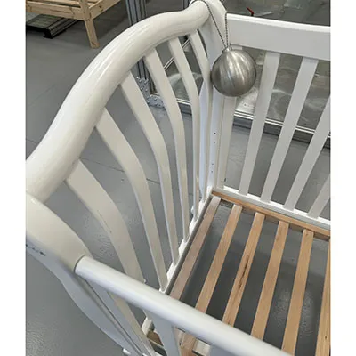 Pătuț din lemn pentru copii în design alb, pe roți. Produs vândut online.