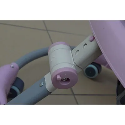 Un baby walker muzical roz și alb, realizat din piese din plastic și metal. Cuvântul