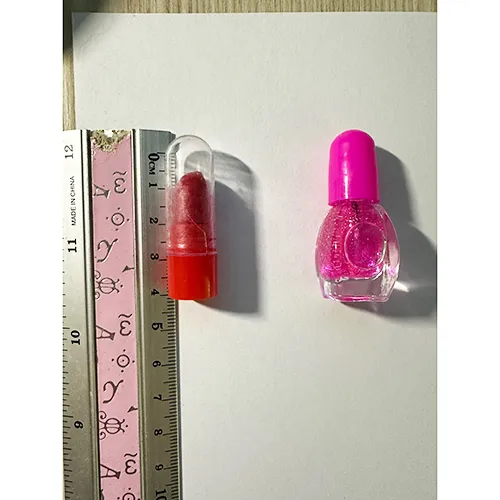 Păpușă din plastic cu accesorii, cum ar fi unghii artificiale, lac de unghii și o geantă.