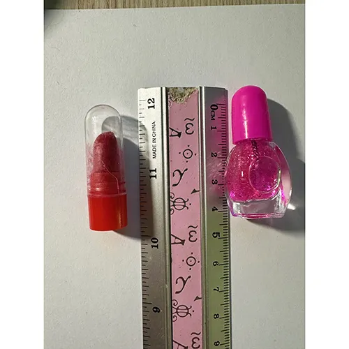 Păpușă din plastic cu accesorii, cum ar fi unghii artificiale, lac de unghii și o geantă.