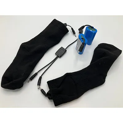 O pereche de șosete negre strânse, echipate cu electronice voluminoase, alimentate cu baterii de litiu.