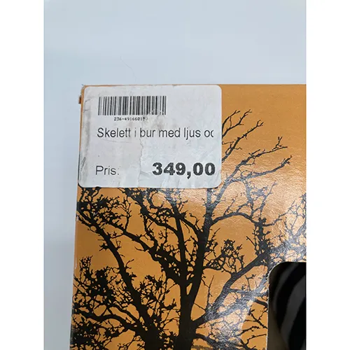 Baterie operată de Halloween produs de decorare cu un schelet într-o cușcă. Produsul are funcții de sunet, lumină și mișcare.