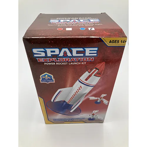 Rachetă de jucărie din spumă albă, cu o înălțime de aproximativ 30 cm, prevăzută cu o bază de elice din plastic roșu, alimentată cu un cablu USB, inclusiv o telecomandă și o rampă de lansare albastră.