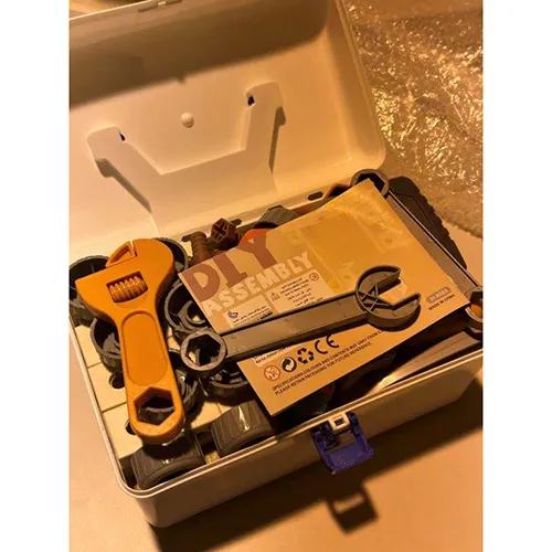 Cutie de scule din plastic alb și albastru, măsurând aproximativ 40x30x30 cm. Umplute cu unelte de joc (inclusiv un șurubelniță acționată de baterii)