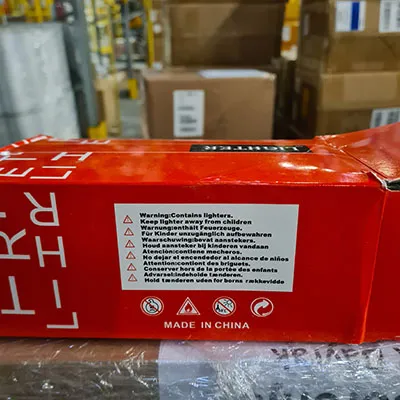 Brichetă metalică cu ceas încorporat. Pe partea de sus a brichetei este atașat un pistol mic.