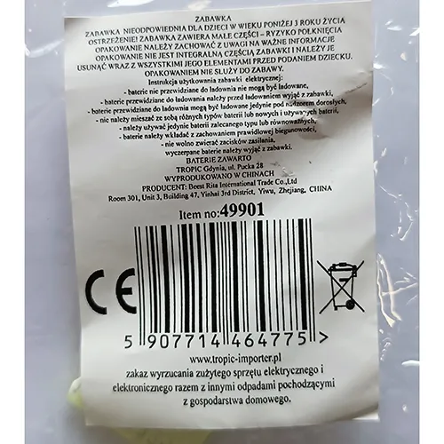 Păpușă de plastic într-o rochie textilă purpurie. Picioarele păpușii sunt plasate într-o minge de plastic transparentă cu pene. Un controler, inclusiv o baterie, este atașat la capul păpușii.