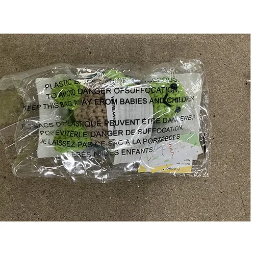 Jucărie moale croșetată în formă de broască țestoasă care ține un semn. Produs vândut online, în special prin TEMU (Identificatorul produsului: 601099805240730).