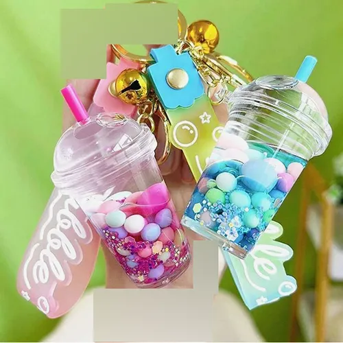 Trei brelocuri cu o figură de ceașcă de ceai cu bule. Figura din plastic conține două lichide neamestecabile (roz și limpede) în recipiente sigilate cu un dop din plastic de cauciuc. Produs vândut online, în special prin intermediul Shein (identificator de produs, SKU: sc2407277808880181).