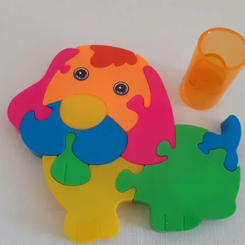 Covor de puzzle din plastic, format din zece piese, în diferite culori, în formă de câine.