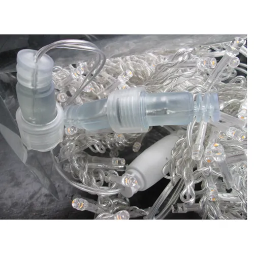 Lanț de iluminat cu lumini LED albastre, sârmă izolată incoloră și o priză care permite extinderea cu membri suplimentari.