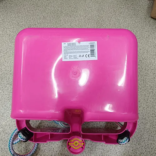 Agățat leagăn de jucărie din plastic. Sistemul de agățare constă dintr-o frânghie care este ancorată în fiecare colț al leagănului și se termină în doi conectori cu capete din plastic. Un corn de plastic este situat în partea centrală din față.