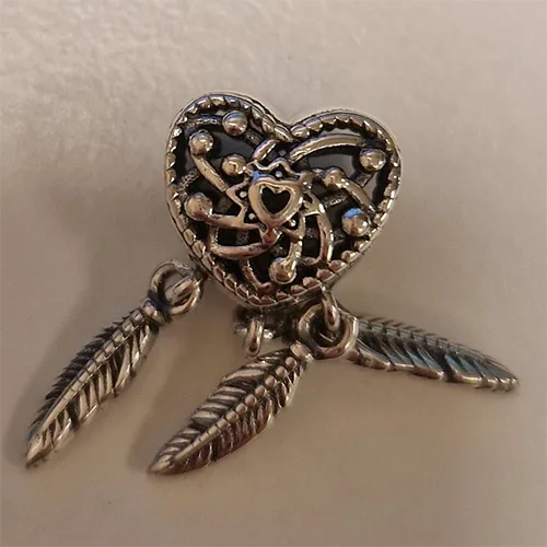 Farmecul brățării în formă de inimă cu pene. Produs vândut online, în special prin intermediul AliExpress.