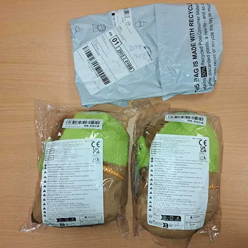 Jucărie de pluș maro și verde în formă de capibara purtând un capac de cap de broască și o mască detașabilă de broască. Produs vândut online, în special prin intermediul Shein (identificator unic: sl25060321981221271).