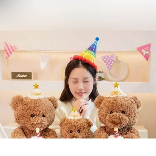 Jucărie moale, în formă de ursuleț de pluș maro, cu o pălărie de ziua de naștere care ține un tort în mâini. Produs vândut online, în special prin intermediul Shein.