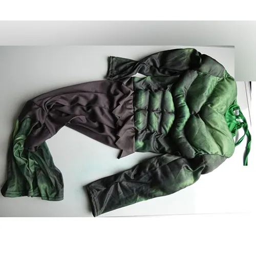Costum Fancy-dress în verde reprezentând Hulk, compus dintr-un costum dintr-o singură bucată cu trunchi căptușit și biceps și o mască rigidă din plastic cu o bandă elastică. Produs vândut online, în special prin intermediul AliExpress (identificator unic de produs: 1005008419344706).