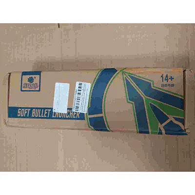 Pistol de aer de jucărie din plastic în alb, albastru și negru, cu o pereche de ochelari, o țintă din carton, patru scoici și zece gloanțe de spumă gri cu cupe de aspirație albastre. Produs vândut online, în special prin intermediul AliExpress (identificator unic de produs: 1005009914110938).