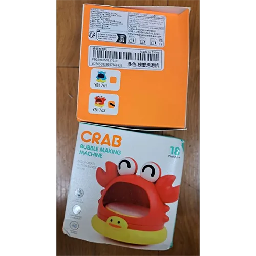 Jucărie de baie roșie și galbenă în formă de crab, cu o deschidere pentru a sufla bule. Produs vândut online, în special prin intermediul Shein (identificator unic: sl25050839197368833).