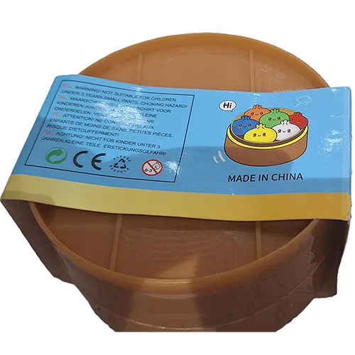 Strângeți jucăria în formă de găluște chinezești într-un recipient de plastic făcut să semene cu un vapor de bambus.