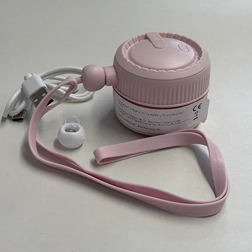 Ventilator de gât portabil reîncărcabil, cu o carcasă din plastic roz și o curea de gât din silicon, vândut împreună cu un cablu de încărcare USB.