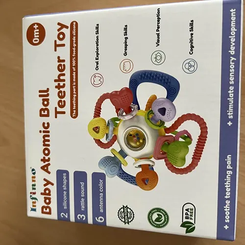 Jucărie dințată și zornăitoare, constând dintr-o minge care conține bile mai mici și diverse accesorii din plastic masticabil moale.